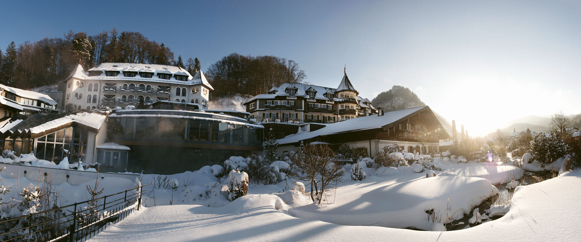 Das 4* Superior Wellnesshotel Ebner's Waldhof am Fuschlsee mit Schnee und Außenpool.