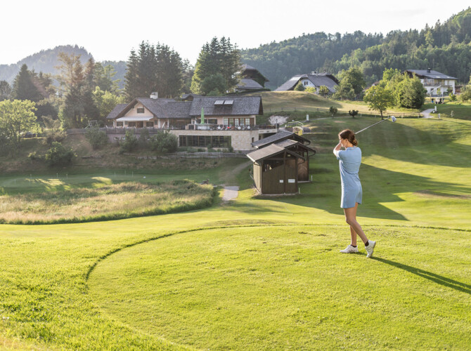 Dame beim Abschlag im hoteleigenen Golfclub des Golfhotel Ebner's Waldhof am Fuschlsee.