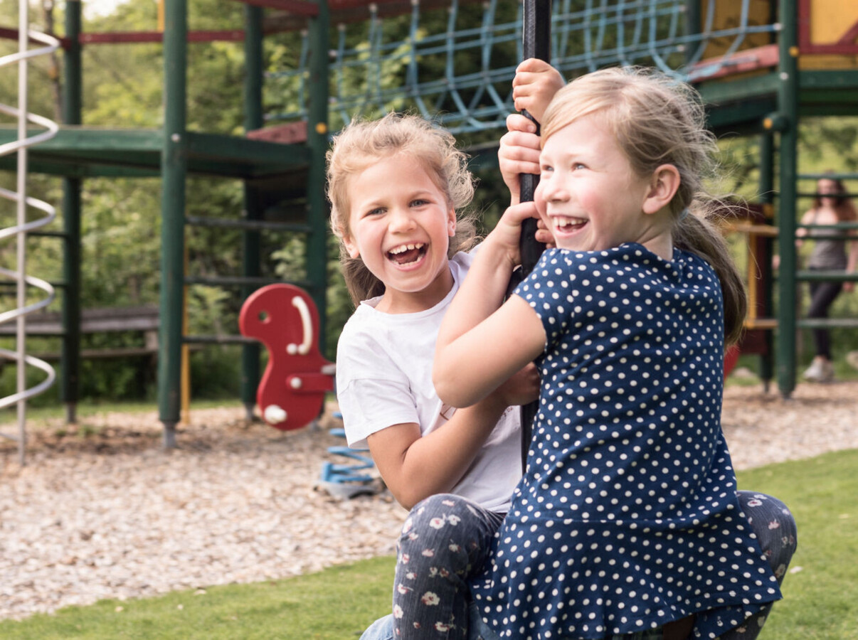 Zwei Kinder beim spielen auf dem Outdoor-Spielplatz im Familienhotel Ebner's Waldhof.